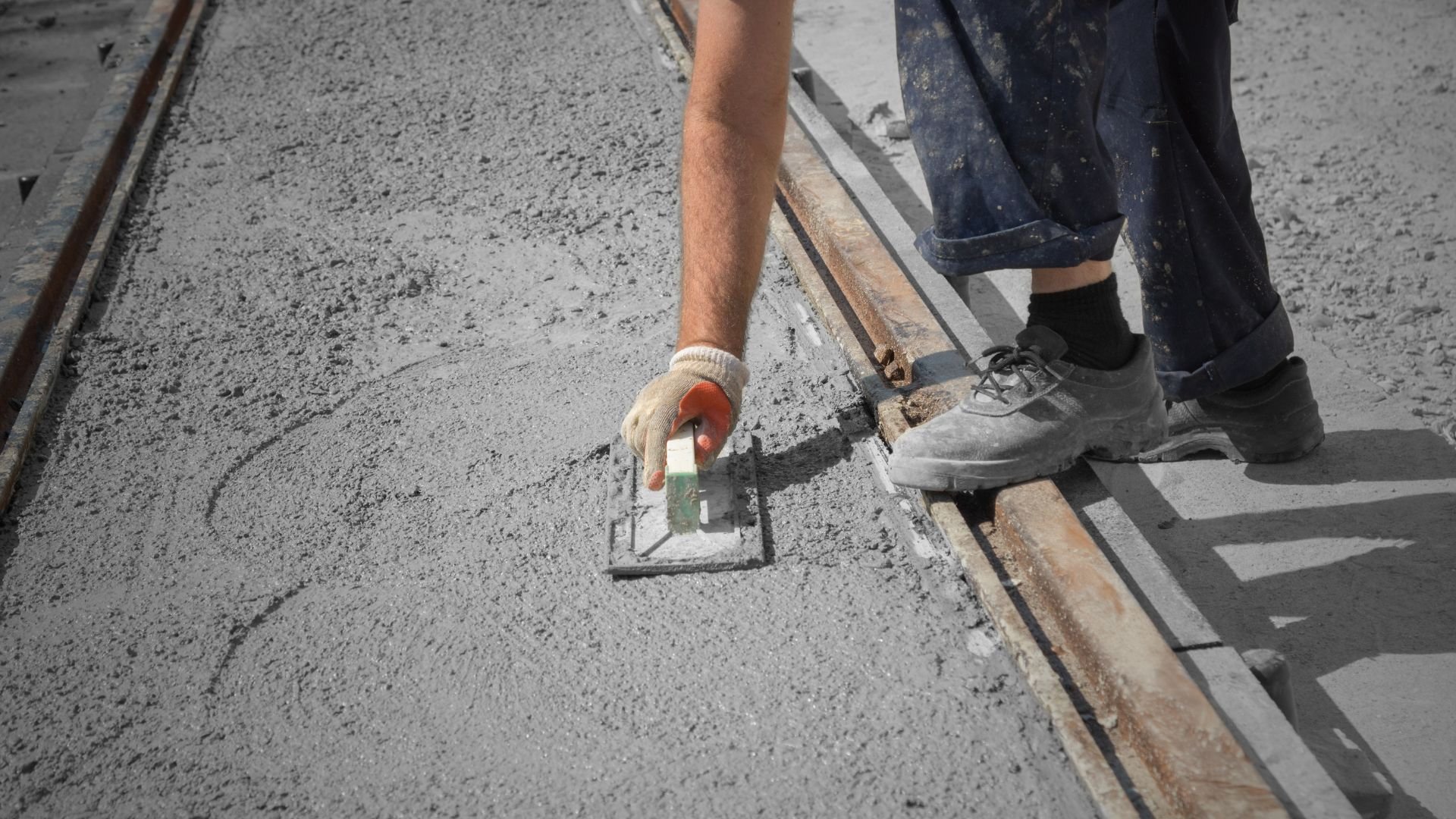 Construction worker smoothing wet concrete with trowel