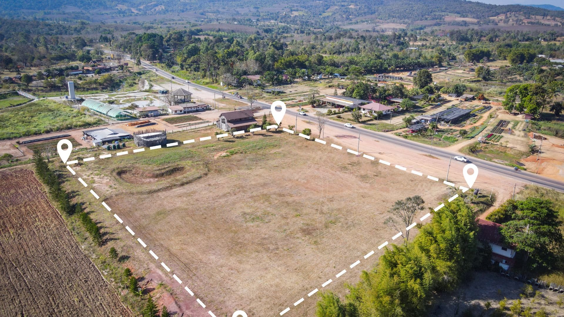 Aerial view of empty lot marked with location pins in rural landscape